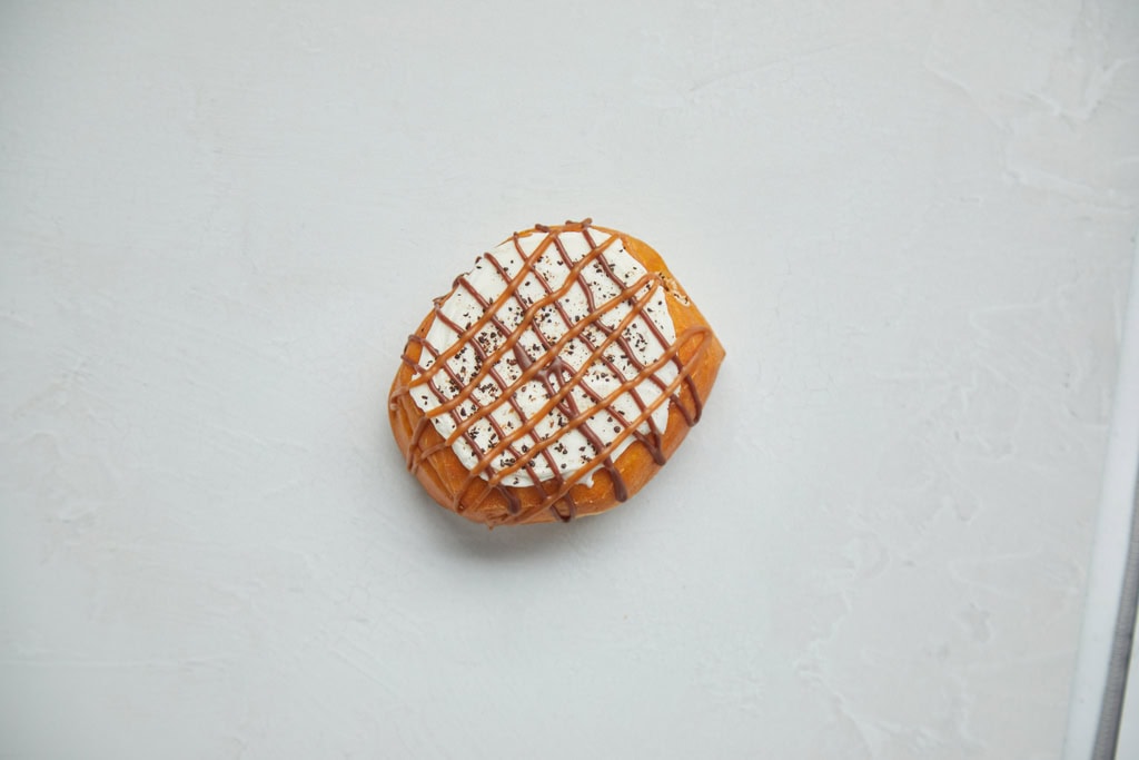 Caramel donut with cream and chocolate drizzle.