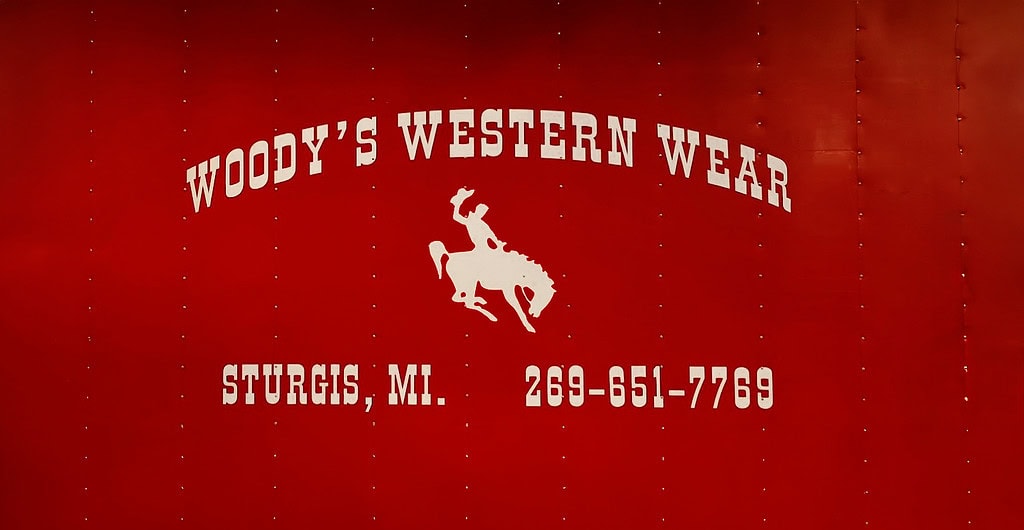 Woody's Western Wear sign with contact information.