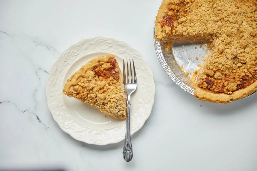Slice of crumb-topped pie on plate.