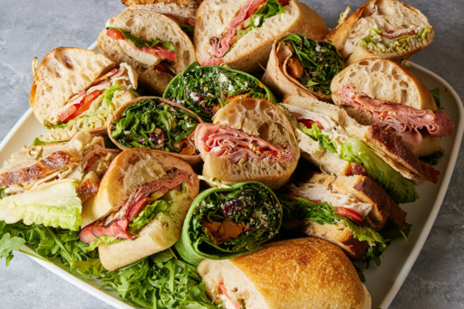 Assorted sandwiches on a platter with greens.