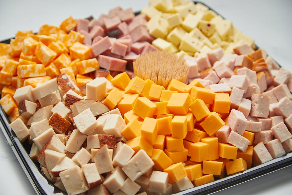 Assorted cheese and meat cubes on platter.