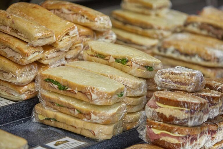 Assorted wrapped sandwiches on display.