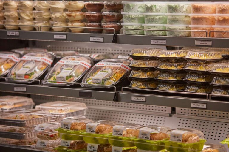 Supermarket shelves with packaged desserts and deli items.