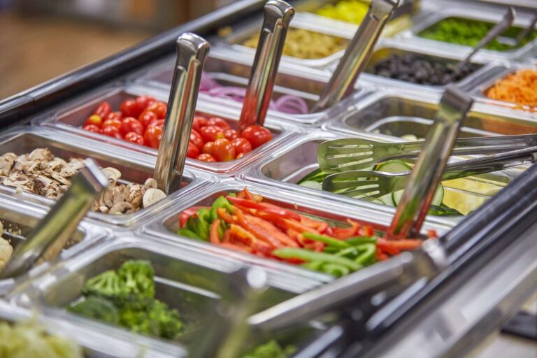 Fresh vegetable salad bar with serving utensils