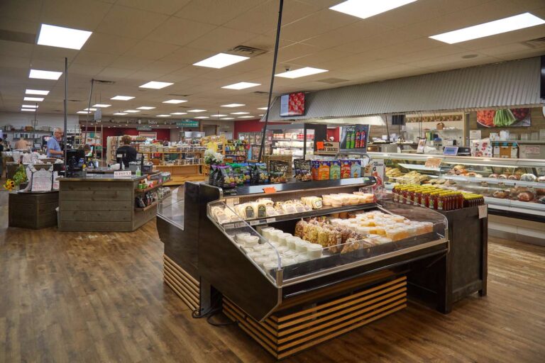 Grocery store interior with cheese and grocery displays.